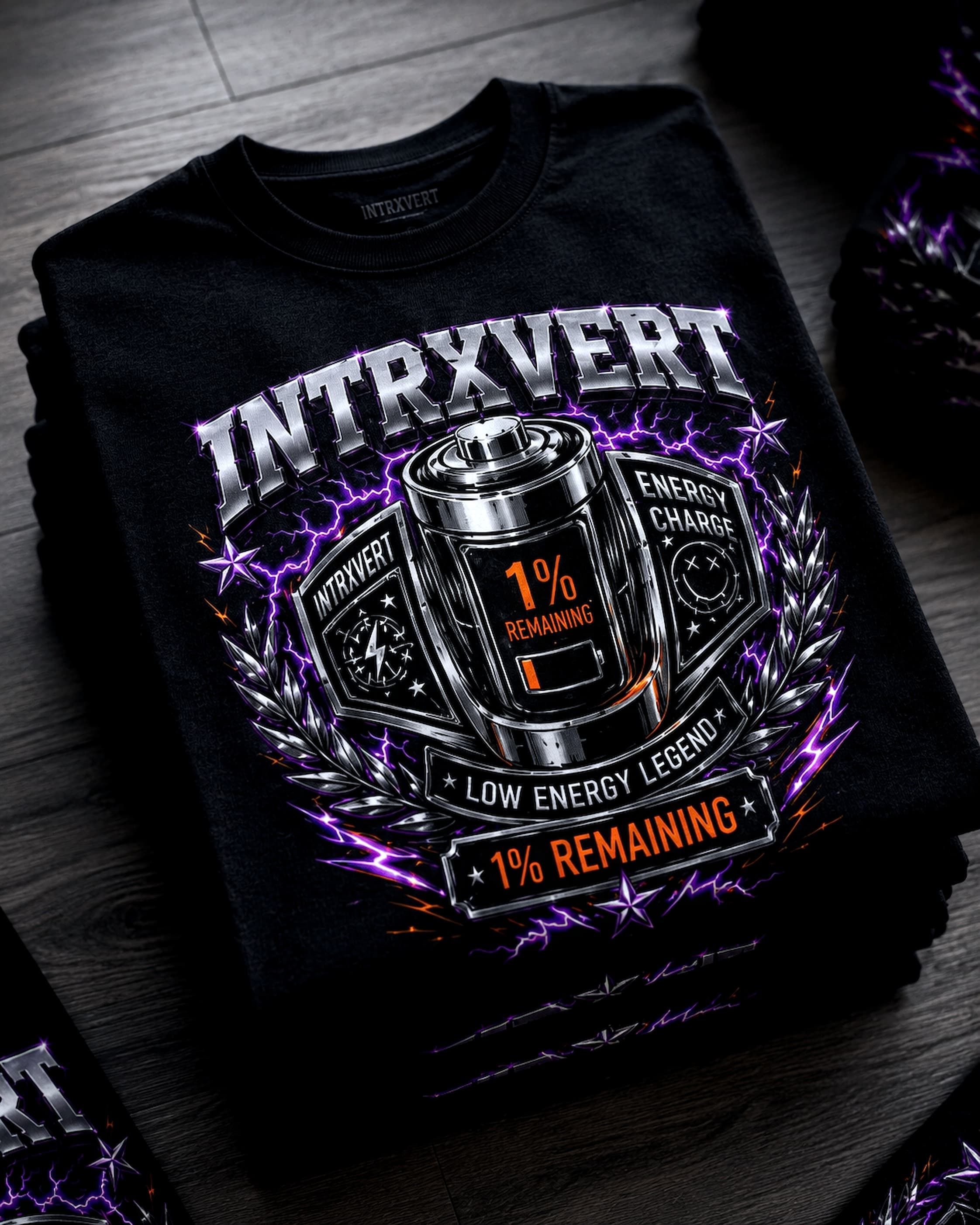 Folded black INTRXVERT tee with metallic battery artwork
